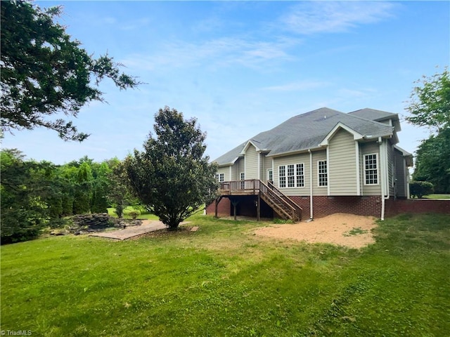 rear view of property featuring stairway, a deck, and a yard