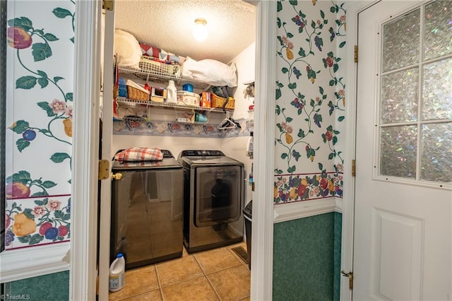 laundry room featuring light tile patterned flooring, washer and dryer, laundry area, and a textured ceiling