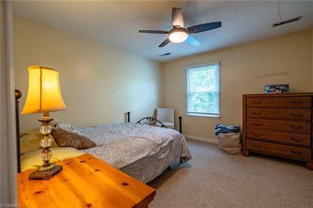 bedroom with carpet floors, baseboards, visible vents, a ceiling fan, and a textured ceiling