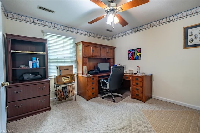 office space with a ceiling fan, visible vents, light carpet, and baseboards