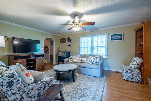 living area featuring crown molding, a textured ceiling, ceiling fan, and wood finished floors