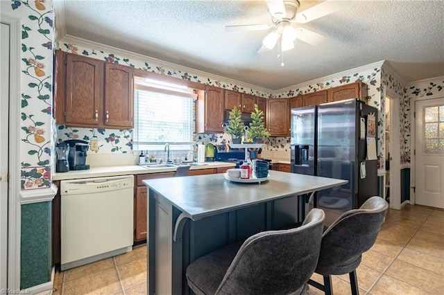 kitchen featuring a textured ceiling, light countertops, and white dishwasher