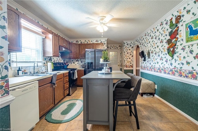 kitchen featuring wallpapered walls, stainless steel fridge, under cabinet range hood, white dishwasher, and black range with electric stovetop