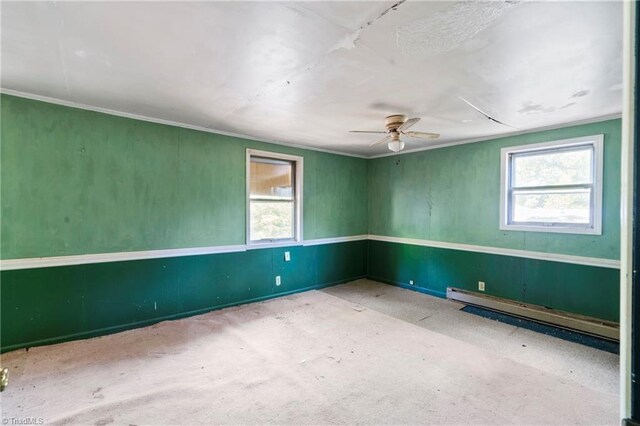 unfurnished room featuring a baseboard heating unit, crown molding, plenty of natural light, and a ceiling fan