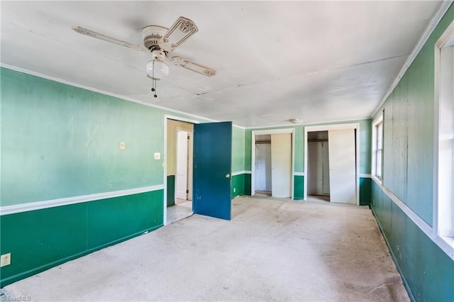 empty room with ceiling fan and concrete flooring