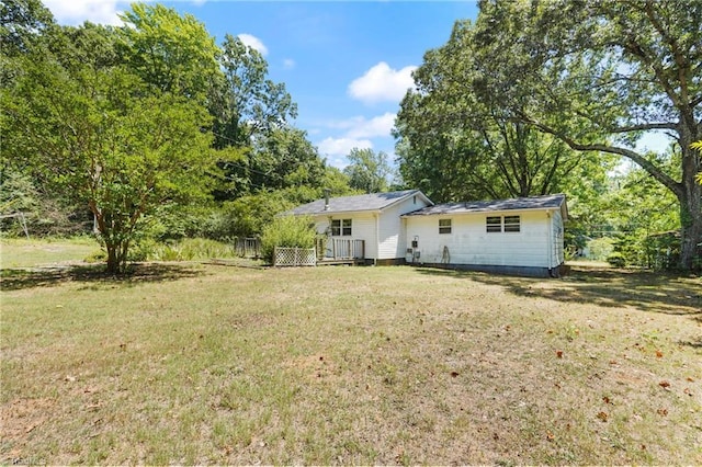 rear view of house featuring a lawn and a wooden deck