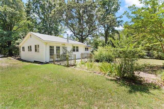 rear view of house with french doors, a yard, and a deck