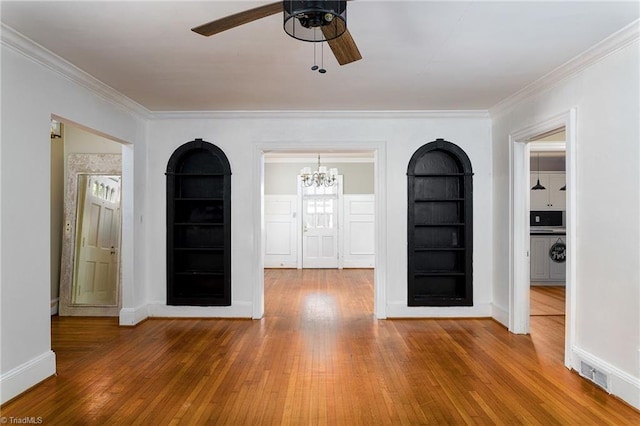 foyer featuring hardwood / wood-style flooring, ceiling fan with notable chandelier, and ornamental molding