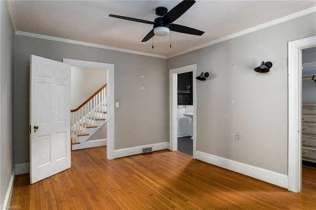 interior space with ornamental molding, wood-type flooring, and ceiling fan