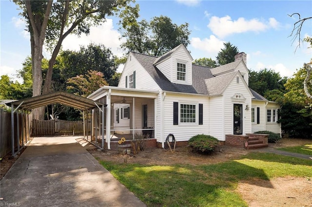 cape cod house with a front yard and a carport