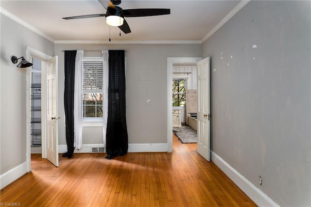 unfurnished bedroom featuring ceiling fan, light hardwood / wood-style flooring, and crown molding