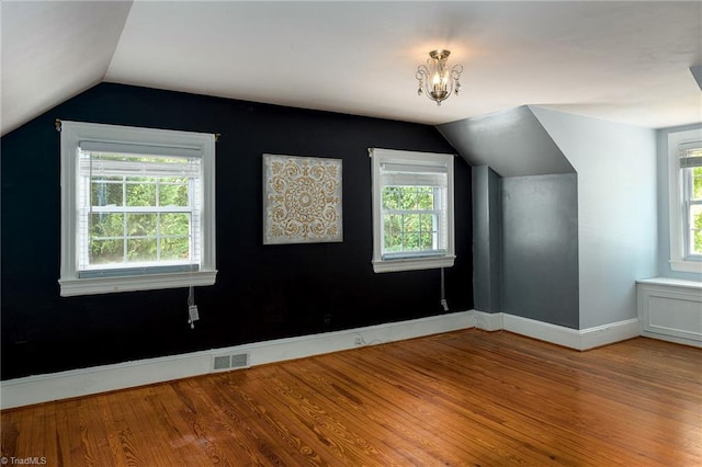 bonus room with hardwood / wood-style flooring and vaulted ceiling