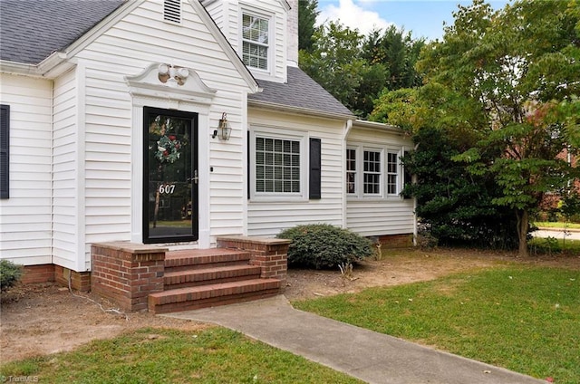 property entrance featuring a lawn