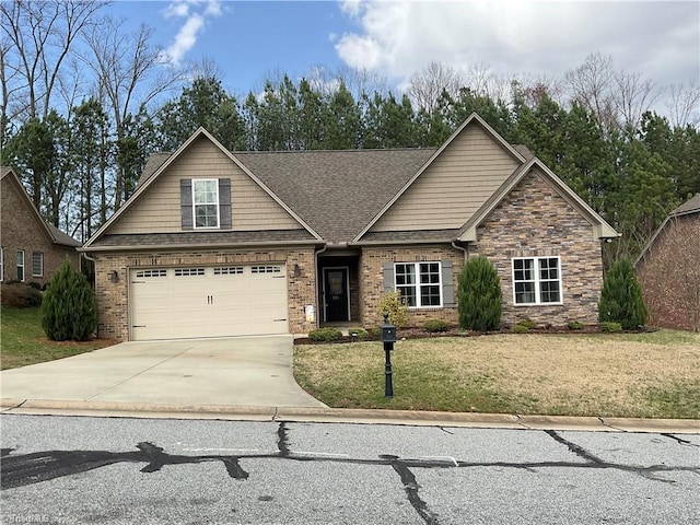 craftsman-style home featuring roof with shingles, concrete driveway, and a front lawn