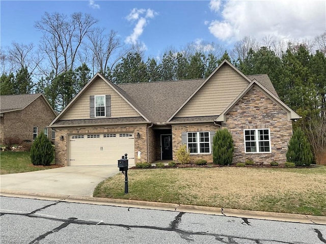 craftsman house with a front yard, concrete driveway, a garage, and roof with shingles