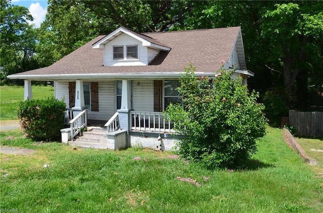 2706 W English Rd, High Point, NC 27262 - bungalow with covered porch, a front yard, and a shingled roof