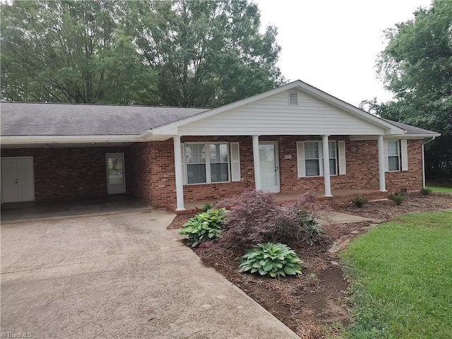 3785 Ellisboro Rd, Stokesdale, NC 27357 - single story home with concrete driveway, brick siding, a porch, a carport, and a shingled roof