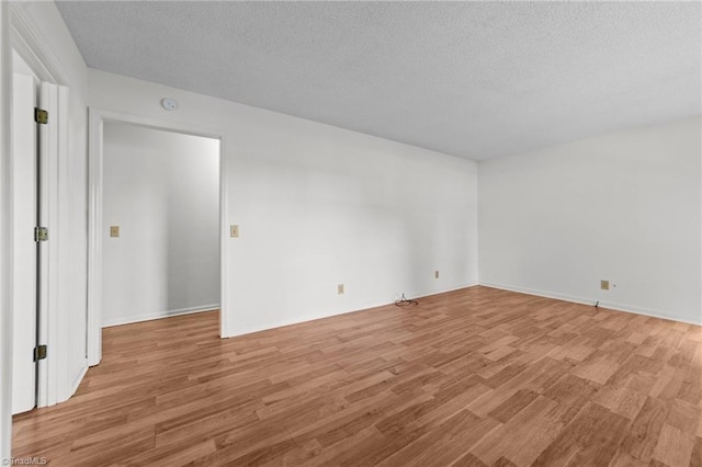 3785 Ellisboro Rd, Stokesdale, NC 27357 - unfurnished room with light wood-style floors, a textured ceiling, and baseboards