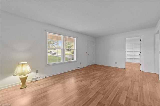 3785 Ellisboro Rd, Stokesdale, NC 27357 - empty room featuring light wood-style floors, baseboards, and a textured ceiling