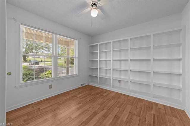 3785 Ellisboro Rd, Stokesdale, NC 27357 - empty room with baseboards, light wood-style flooring, ceiling fan, and a textured ceiling