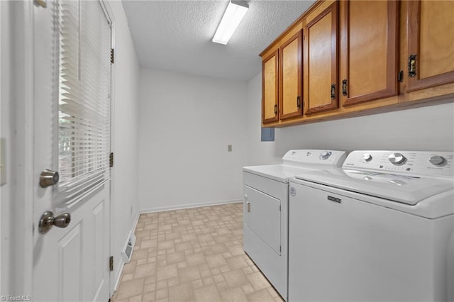 3785 Ellisboro Rd, Stokesdale, NC 27357 - washroom with washing machine and dryer, cabinet space, a textured ceiling, and baseboards