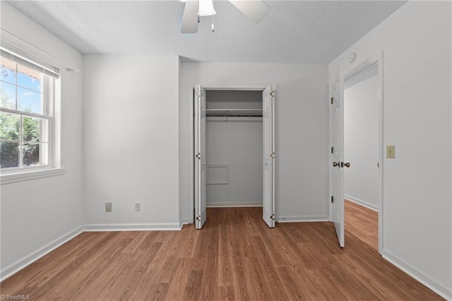 3785 Ellisboro Rd, Stokesdale, NC 27357 - unfurnished bedroom featuring wood finished floors, a textured ceiling, a closet, baseboards, and ceiling fan