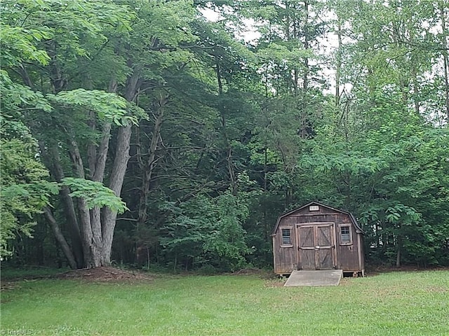 3785 Ellisboro Rd, Stokesdale, NC 27357 - view of green lawn featuring a storage unit, an outbuilding, and a view of trees