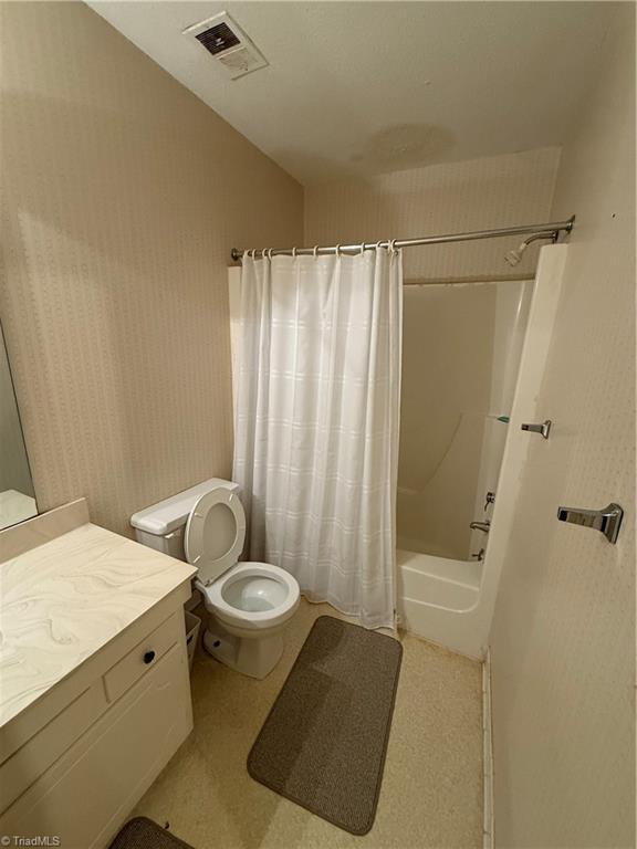 full bathroom featuring vanity, shower / bath combination with curtain, and toilet