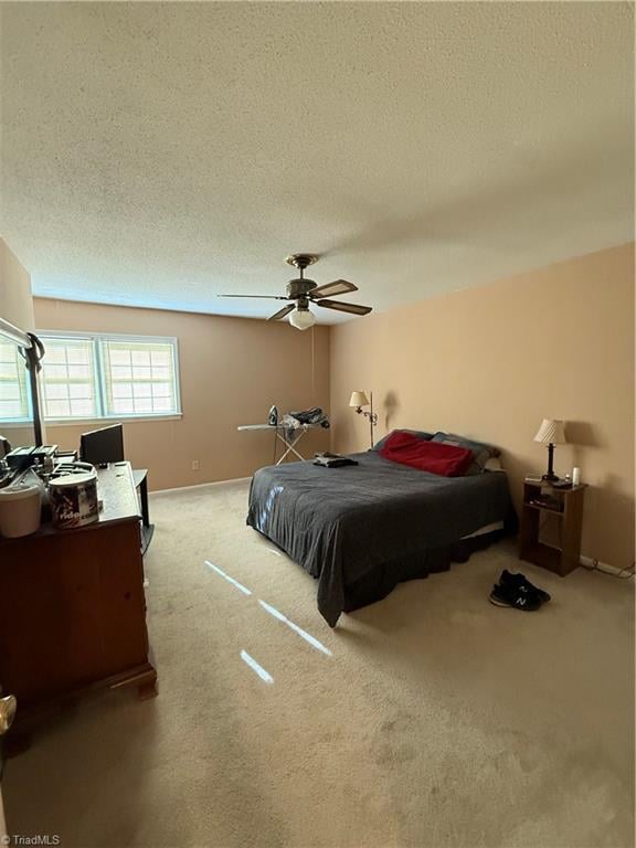 carpeted bedroom with a textured ceiling and ceiling fan