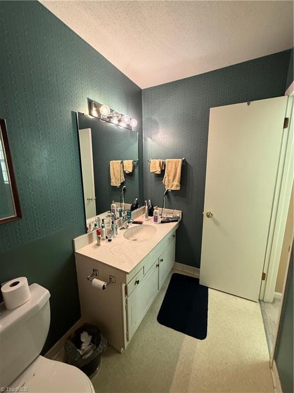 bathroom featuring vanity, a textured ceiling, and toilet