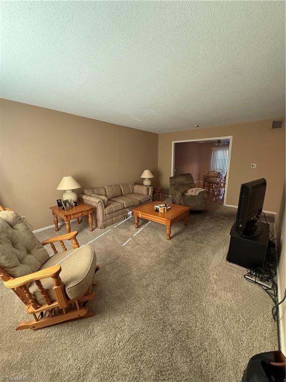 unfurnished living room with carpet and a textured ceiling