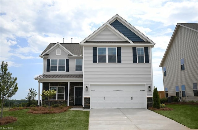 view of front facade with an attached garage, a front yard, a standing seam roof, stone siding, and driveway