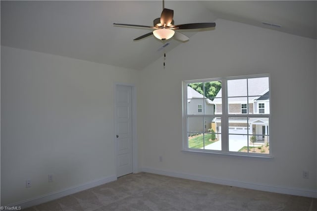 spare room featuring visible vents, baseboards, ceiling fan, carpet, and vaulted ceiling