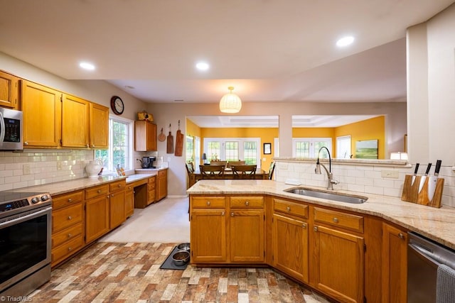 121 Walter Hagen Dr, Mebane, NC 27302 - kitchen with appliances with stainless steel finishes, a sink, a peninsula, decorative backsplash, and recessed lighting