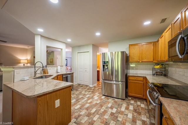 121 Walter Hagen Dr, Mebane, NC 27302 - kitchen featuring stainless steel appliances, a sink, tasteful backsplash, light stone counters, and recessed lighting