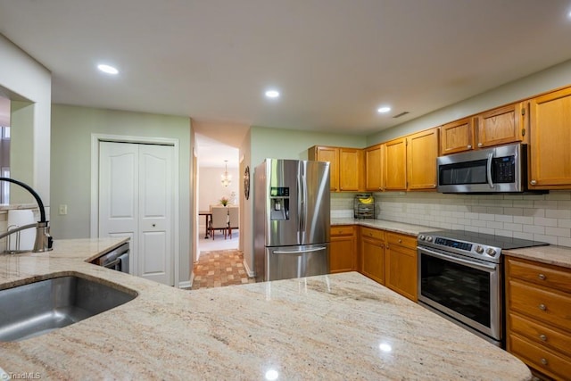 121 Walter Hagen Dr, Mebane, NC 27302 - kitchen with stainless steel appliances, a sink, backsplash, light stone countertops, and recessed lighting