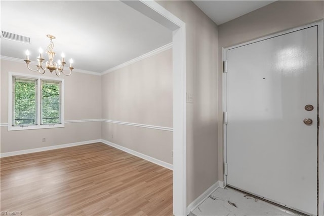 entryway featuring a chandelier, crown molding, baseboards, and light wood finished floors