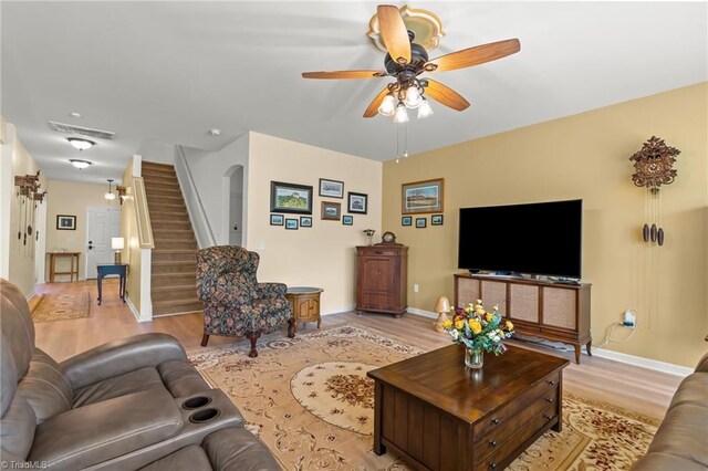 1720 Ridge Bluff Cir, Rural Hall, NC 27045 - living room featuring light wood-type flooring, a ceiling fan, stairs, and arched walkways
