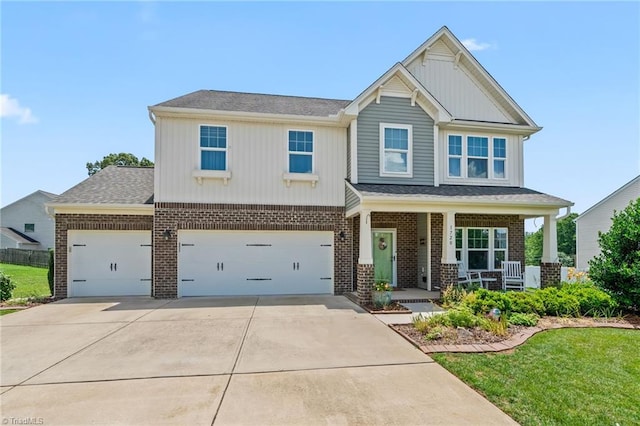1720 Ridge Bluff Cir, Rural Hall, NC 27045 - view of front of home featuring covered porch, brick siding, concrete driveway, a front lawn, and board and batten siding