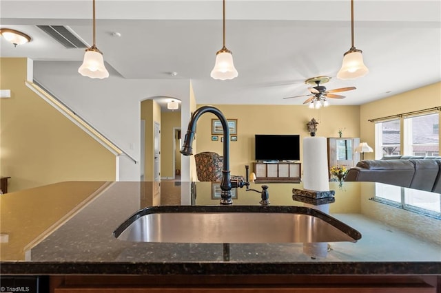 1720 Ridge Bluff Cir, Rural Hall, NC 27045 - kitchen with open floor plan, arched walkways, ceiling fan, pendant lighting, and dark stone counters