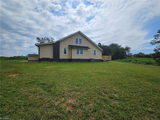 rear view of house with a deck, a yard, and cooling unit