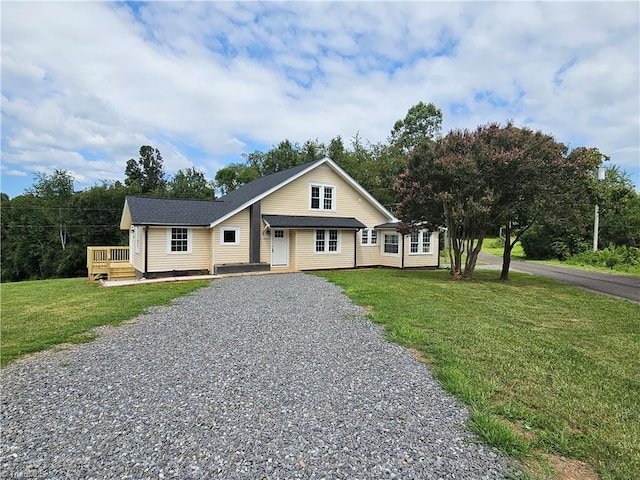 view of front facade featuring driveway, a deck, and a front lawn