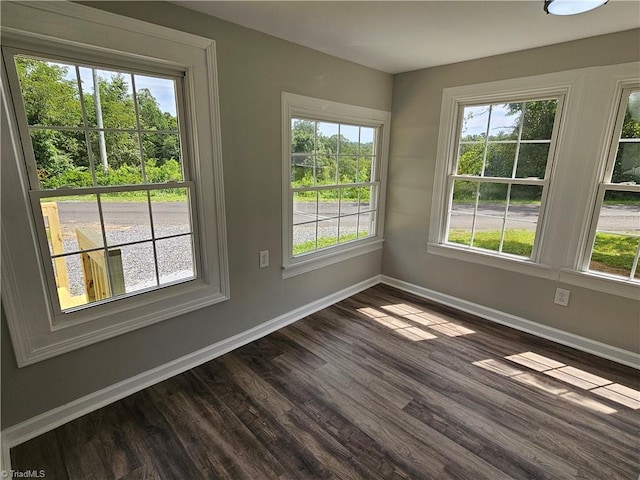 empty room featuring dark wood-style floors and baseboards