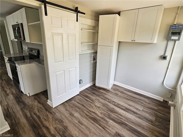 kitchen featuring a barn door, electric range oven, open shelves, stainless steel microwave, and dark wood finished floors