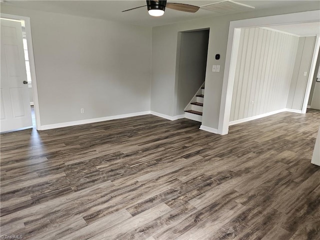 interior space featuring dark wood-style floors, stairway, baseboards, and a ceiling fan