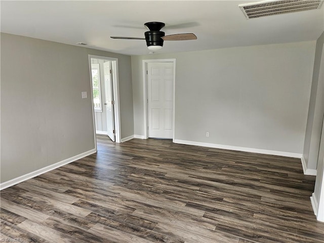 empty room with baseboards, visible vents, ceiling fan, and dark wood-style flooring