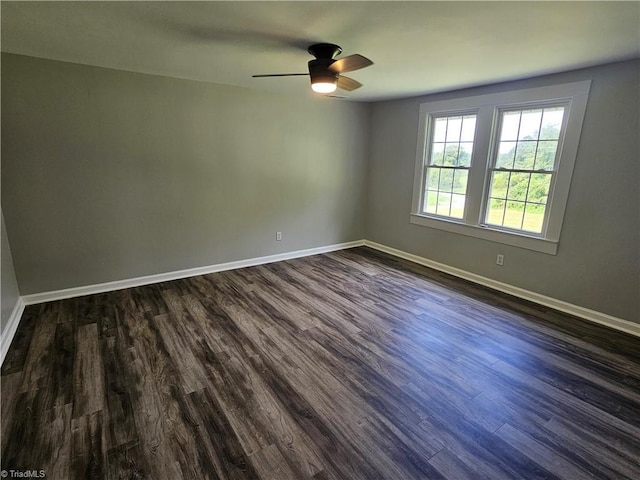 empty room featuring dark wood-style floors, ceiling fan, and baseboards