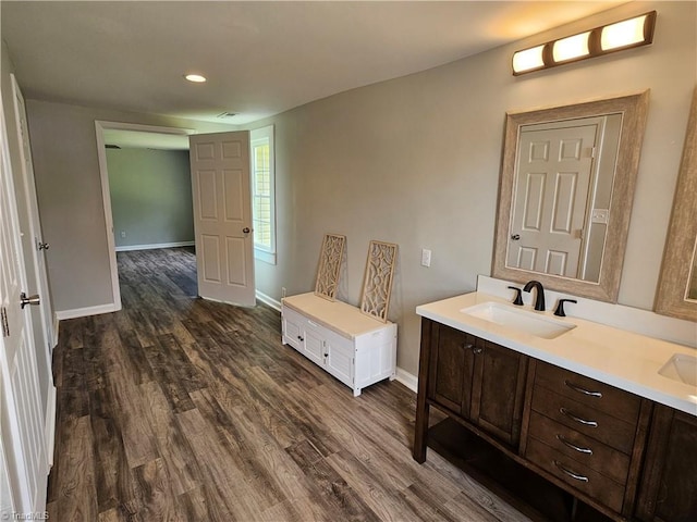 bathroom featuring a sink, baseboards, and wood finished floors