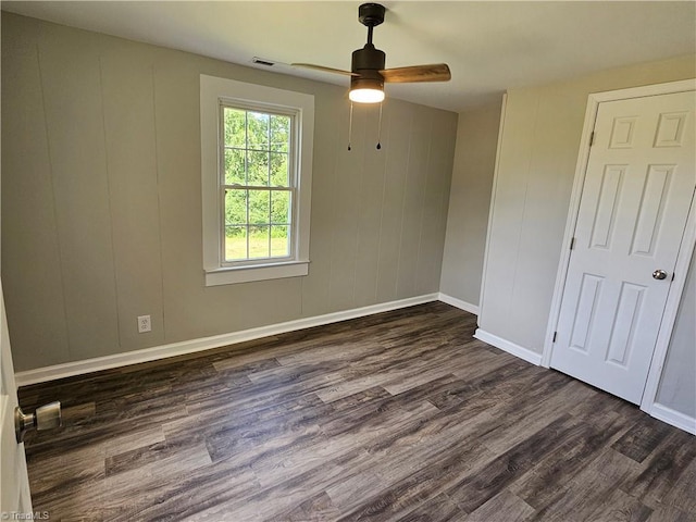 unfurnished bedroom featuring a ceiling fan, dark wood-style flooring, visible vents, and baseboards