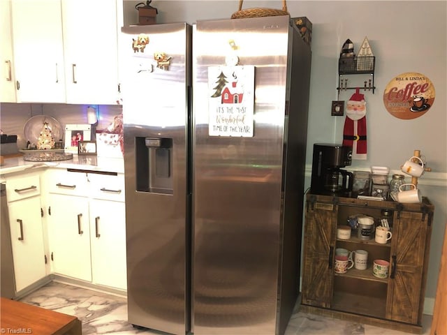 kitchen featuring tasteful backsplash, white cabinetry, and stainless steel refrigerator with ice dispenser